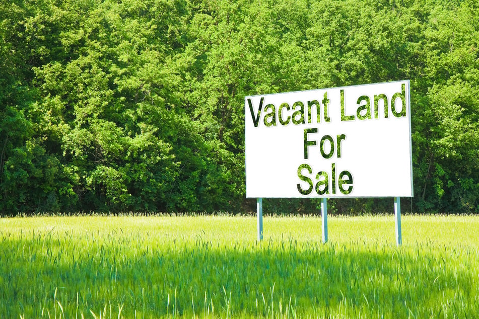 Advertising billboard immersed in a rural scene with Vacant Land for Sale written on it - image with copy space